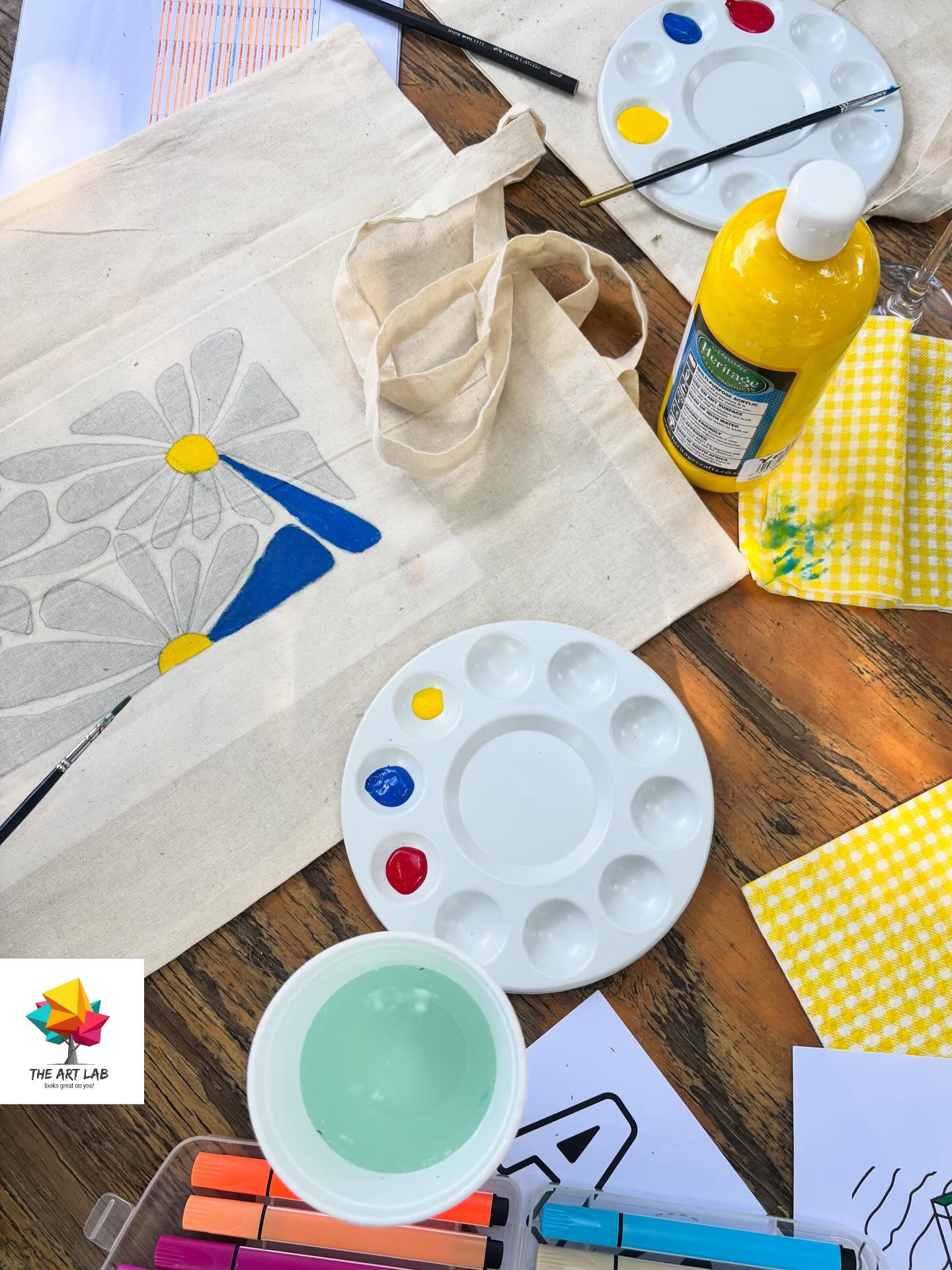 Tote bags and paint prepared for an ArtLab activity